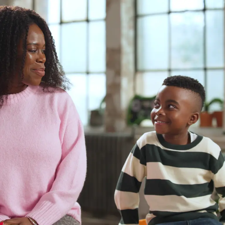 A mother and son from the video looking at each other