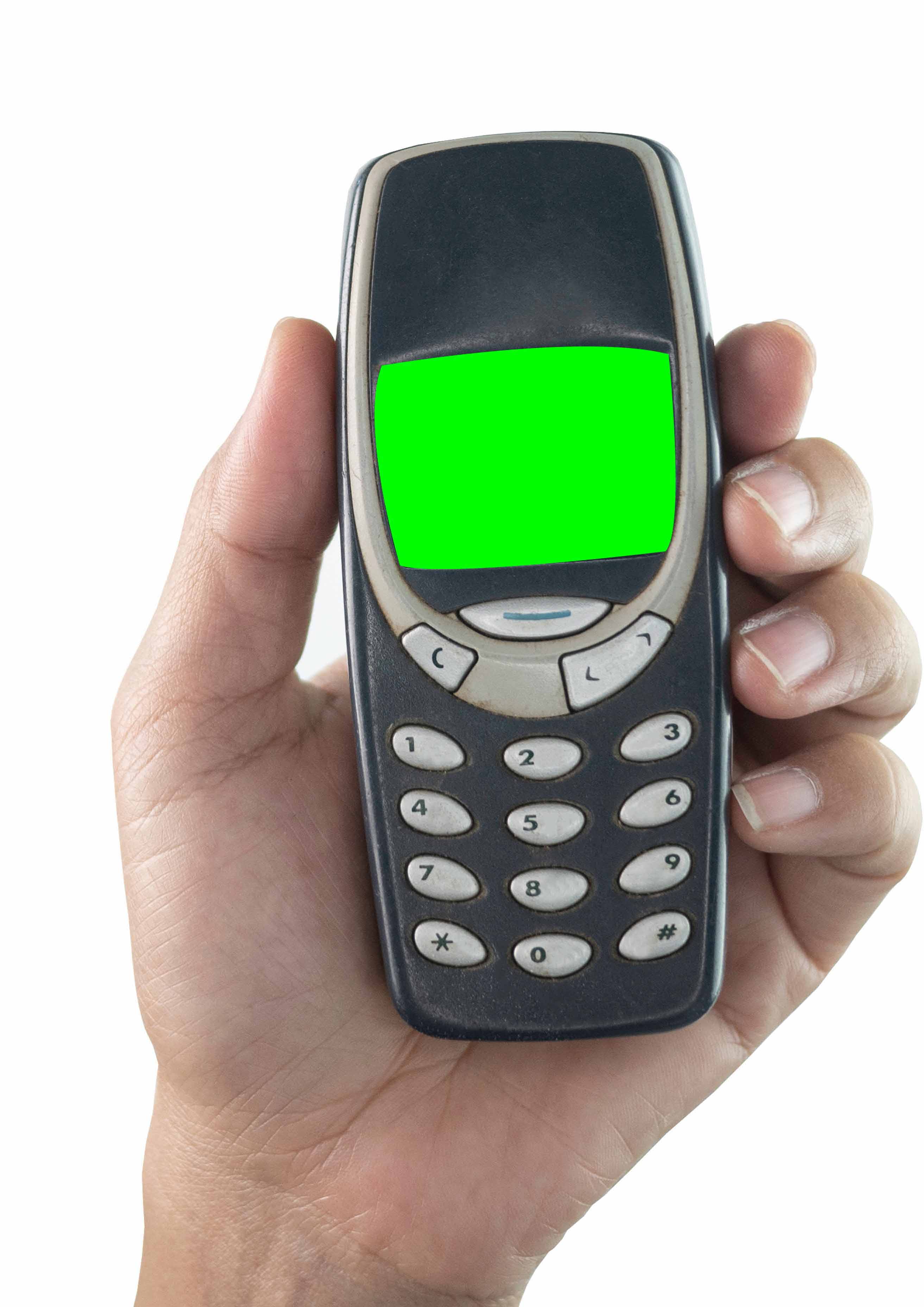 A person holds a Nokia 3210 in the palm of their hand 