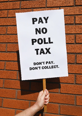 A person is stood outside against a wall. Their hand is raised and they’re holding a placard aloft that says, “Pay no poll tax. Don't pay. Don’t collect.”