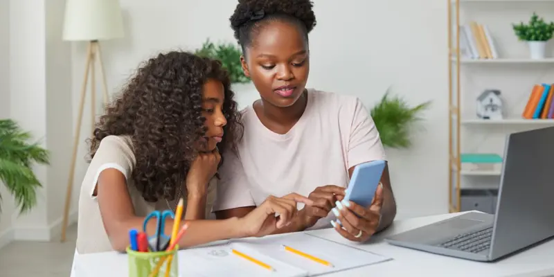 Woman and young girl looking at a mobile phone