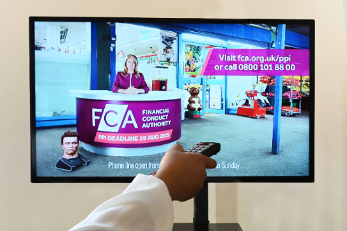 A woman points a remote at the TV. On the screen, there's an FCA advert reminding people of the deadline to claim for PPI refunds. There is a robot Arnold Schwarzenegger head in the corner of the advert, about to roll across towards the centre of the screen.