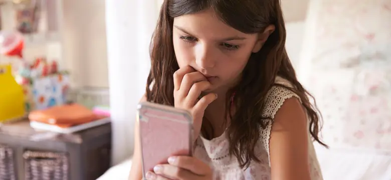 A young girl looking at a phone